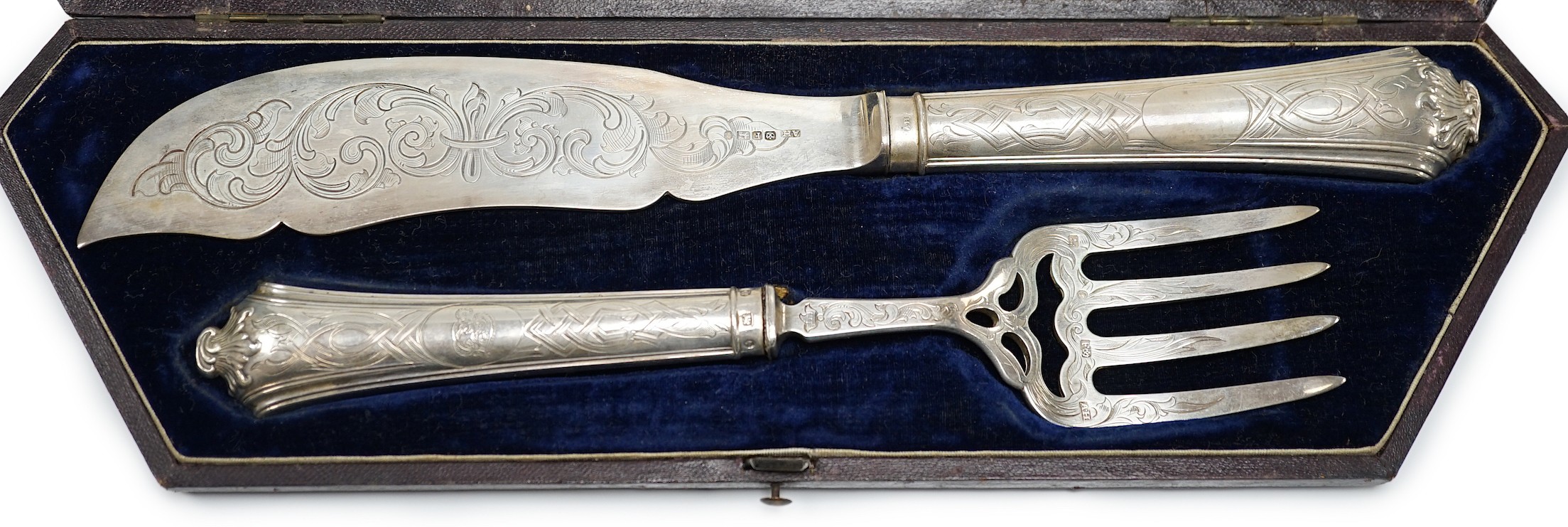 A cased pair of Victorian silver fish servers, by Aaron Hadfield, Sheffield, 1849, with engraved decoration, slice 30.8cm, (loaded handles).